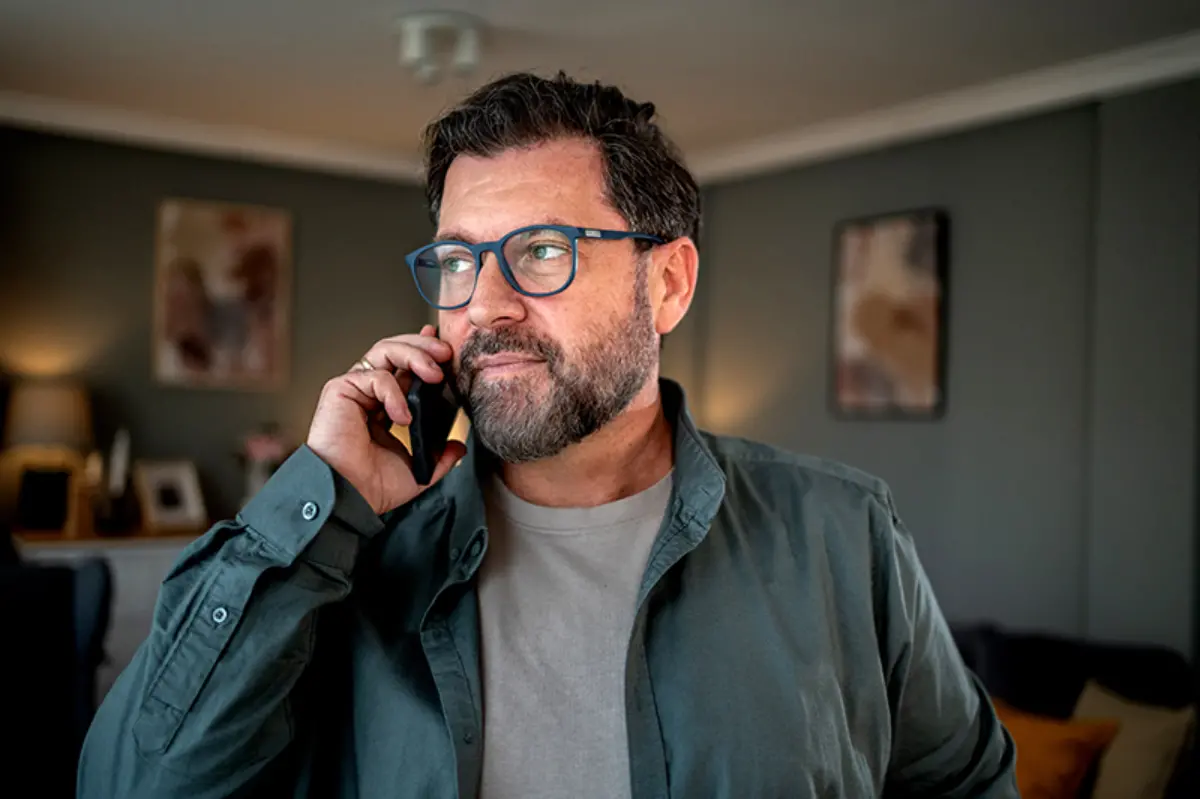 Man wearing glasses on phone with HOMELINK for home health support